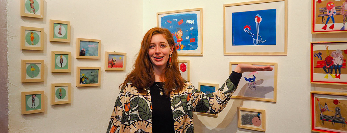 photo d' Aurélia Picq devant ses dessins lors d'une expo
